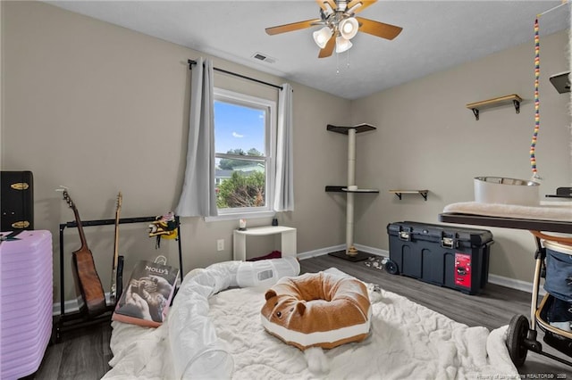 bedroom featuring visible vents, baseboards, ceiling fan, and wood finished floors