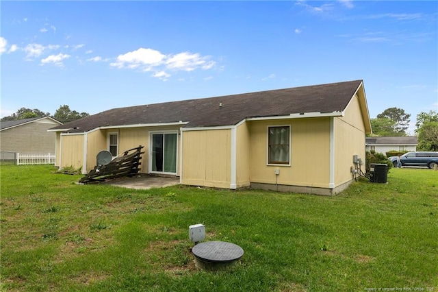 back of property featuring fence, a yard, and cooling unit