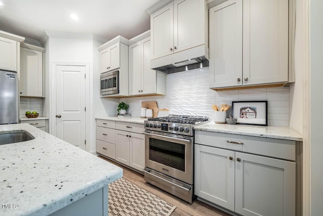 151 Monteith Dr, Chapel Hill, NC 27516 - kitchen featuring stainless steel appliances, decorative backsplash, light wood finished floors, under cabinet range hood, and ornamental molding