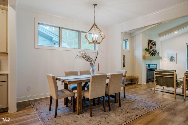 151 Monteith Dr, Chapel Hill, NC 27516 - dining area with a chandelier, crown molding, healthy amount of natural light, wood finished floors, and a glass covered fireplace