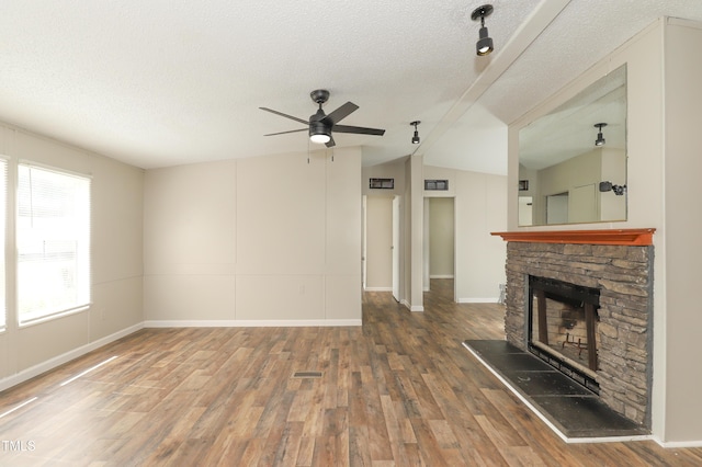 1201 Red Sunset Pl, Siler City, NC 27344 - unfurnished living room with a fireplace, lofted ceiling, a textured ceiling, and wood finished floors