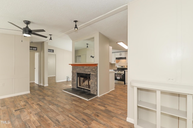 1201 Red Sunset Pl, Siler City, NC 27344 - unfurnished living room featuring wood finished floors, a ceiling fan, a textured ceiling, a stone fireplace, and vaulted ceiling