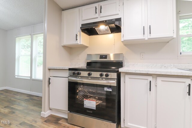 1201 Red Sunset Pl, Siler City, NC 27344 - kitchen with a textured ceiling, under cabinet range hood, stainless steel range with electric cooktop, wood finished floors, and white cabinets