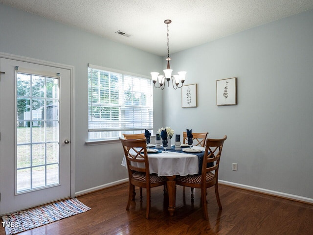 dining area with wood finished floors, a chandelier, baseboards, and a textured ceiling