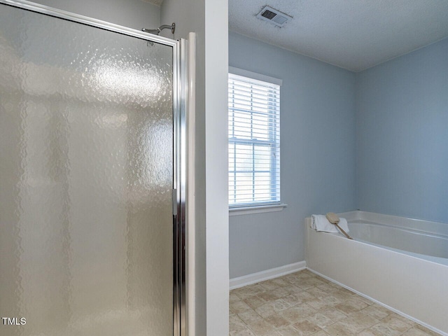 bathroom with a stall shower, a garden tub, and baseboards