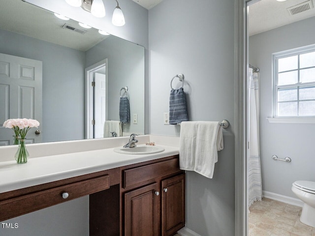 bathroom with vanity, toilet, and baseboards