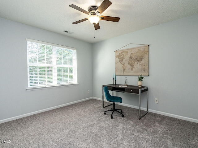 carpeted office space featuring ceiling fan, a textured ceiling, and baseboards