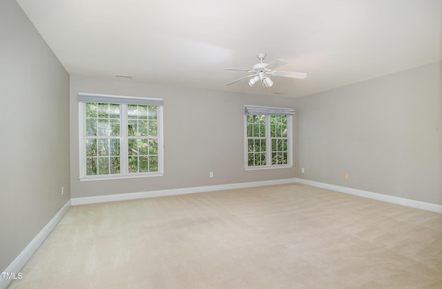 spare room with baseboards, a ceiling fan, and light colored carpet