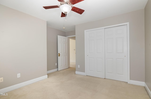 unfurnished bedroom with baseboards, light carpet, and a closet