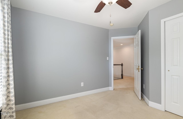 unfurnished bedroom with baseboards, ceiling fan, and light colored carpet