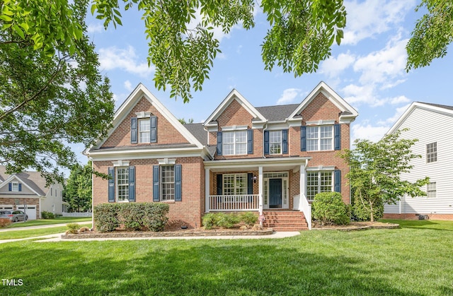 view of front of home featuring a porch, brick siding, and a front yard