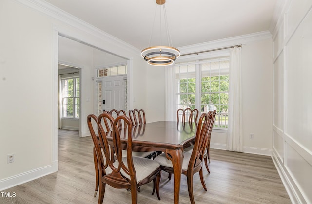 dining area featuring plenty of natural light, ornamental molding, and light wood-style floors