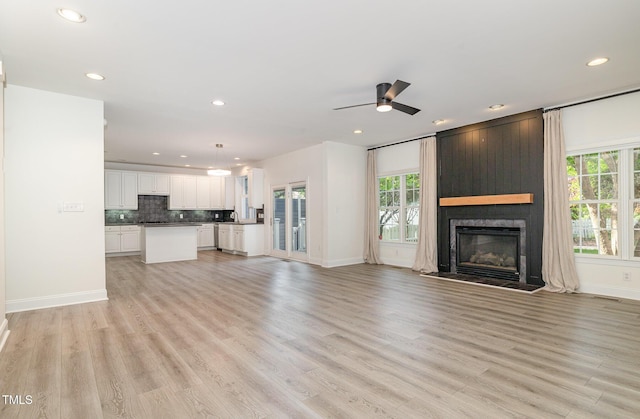 unfurnished living room featuring recessed lighting, a wealth of natural light, and light wood-style flooring