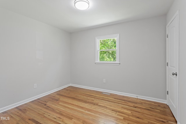 unfurnished room with light wood-style flooring and baseboards