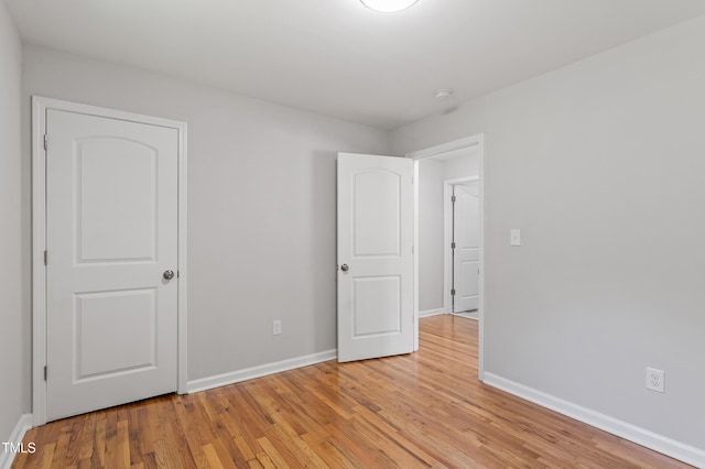 unfurnished bedroom featuring light wood-style floors and baseboards