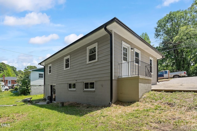 view of side of property featuring a yard and central AC