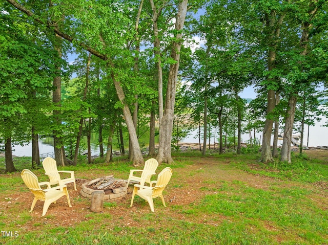 view of yard with a water view and a fire pit