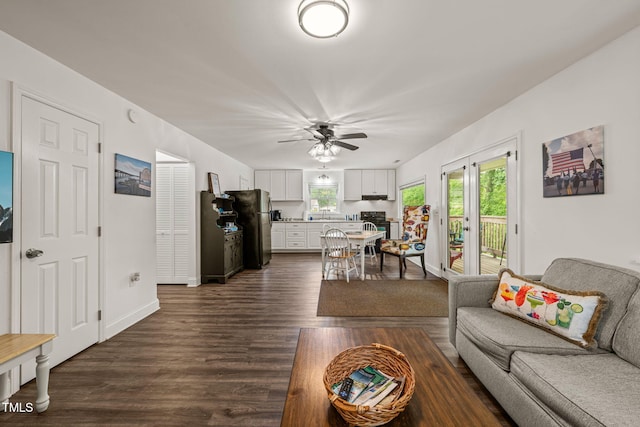 living area featuring ceiling fan and dark wood finished floors