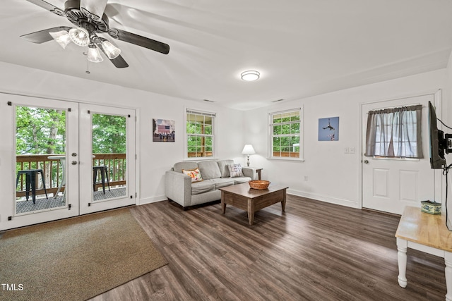 living room with baseboards, ceiling fan, and dark wood-style flooring