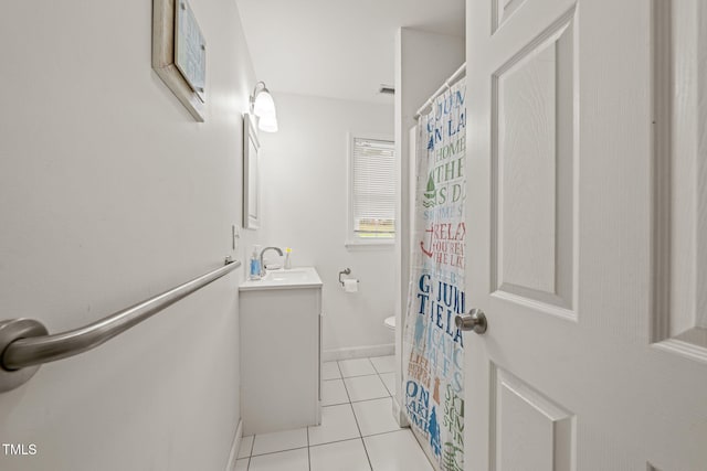 bathroom with tile patterned flooring, vanity, toilet, baseboards, and visible vents