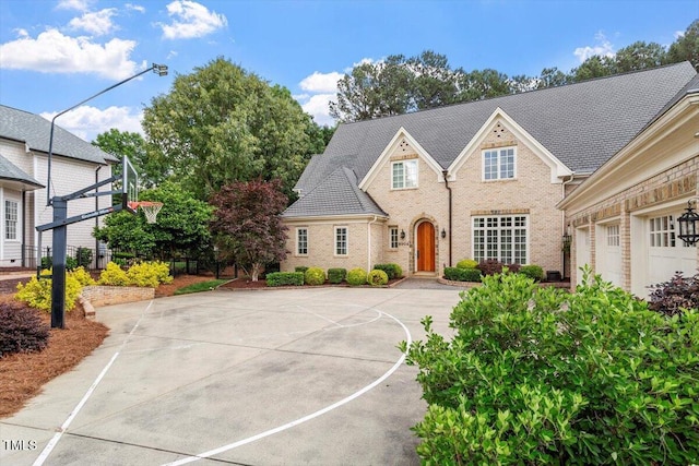 view of front of property with basketball hoop and brick siding