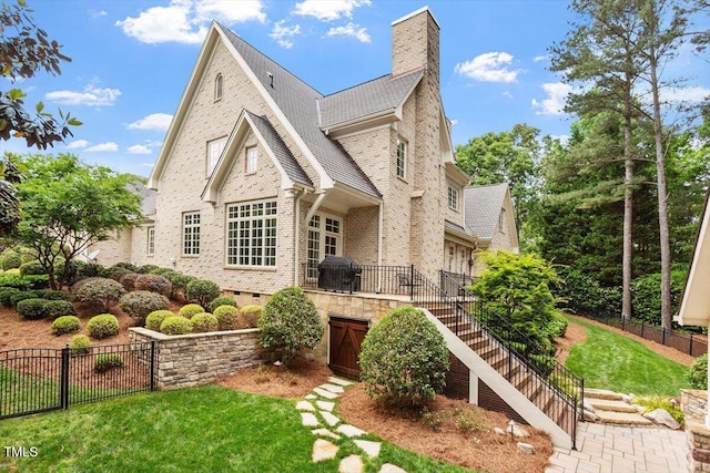 view of front of home with stairway, a chimney, brick siding, crawl space, and roof with shingles