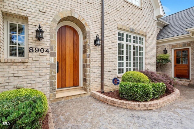 view of exterior entry with brick siding