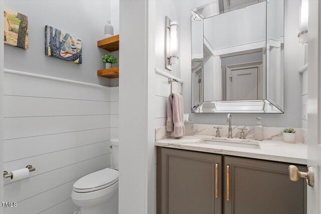 half bath featuring toilet and vanity