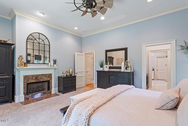 bedroom featuring crown molding, a high end fireplace, light colored carpet, recessed lighting, and connected bathroom