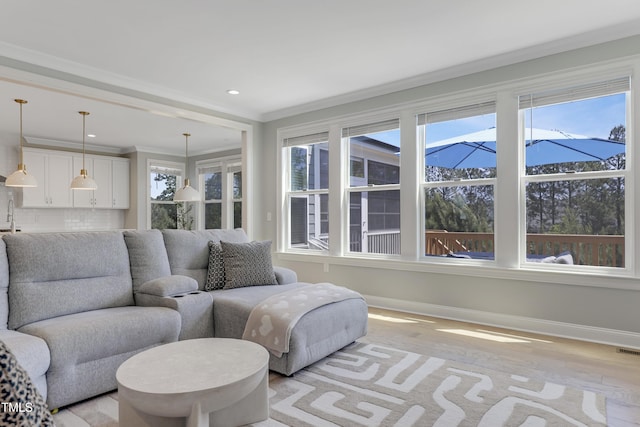 living area featuring crown molding, recessed lighting, baseboards, light wood-type flooring, and visible vents