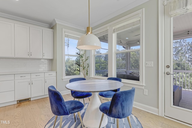 dining area with visible vents, crown molding, baseboards, and light wood finished floors