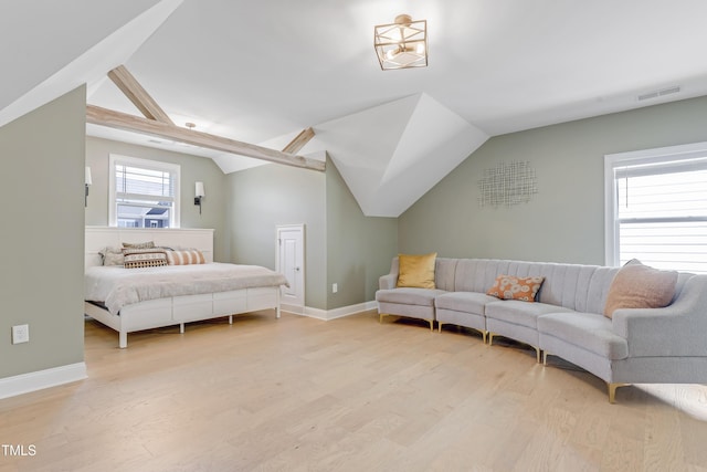 bedroom featuring visible vents, light wood finished floors, lofted ceiling, and baseboards