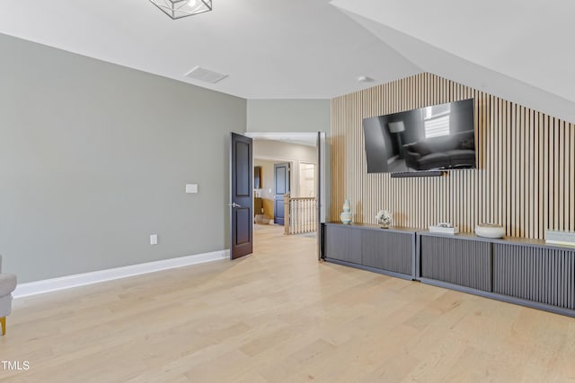 kitchen featuring vaulted ceiling, visible vents, baseboards, and light wood finished floors