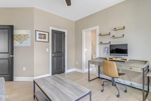 office area with baseboards, ceiling fan, and light wood finished floors