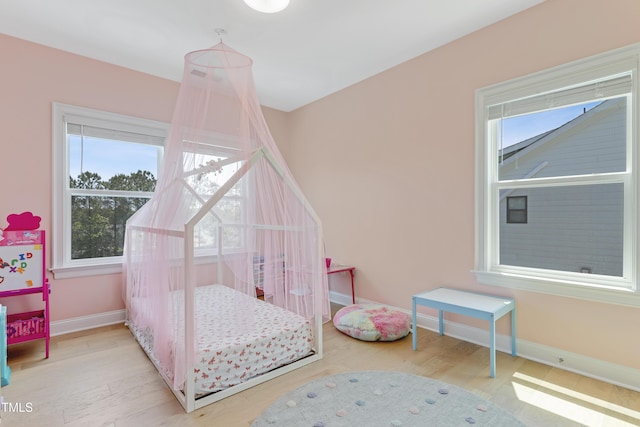 bedroom with baseboards and light wood finished floors