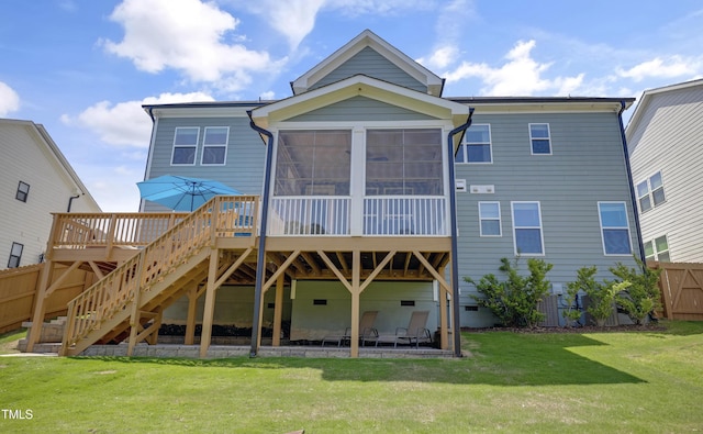 rear view of property with fence, a sunroom, a deck, stairway, and a yard