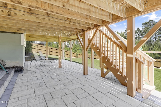 view of patio with fence and stairway