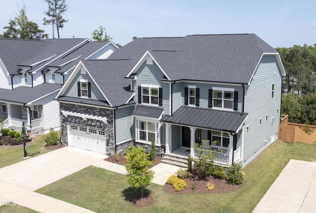 craftsman-style home featuring roof with shingles, a porch, a front yard, a standing seam roof, and driveway
