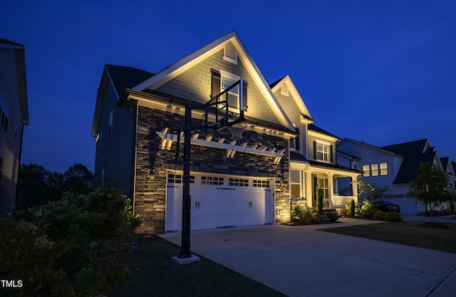 view of front facade featuring concrete driveway, stone siding, and a garage