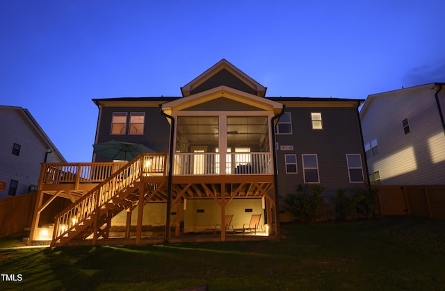 rear view of property with fence, a yard, stairway, and a deck