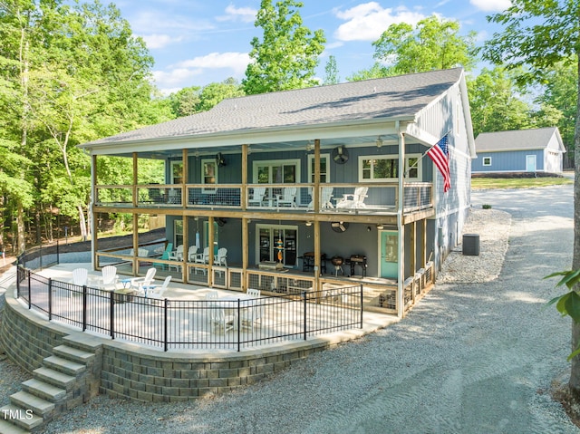 rear view of house featuring cooling unit, a shingled roof, and a patio area
