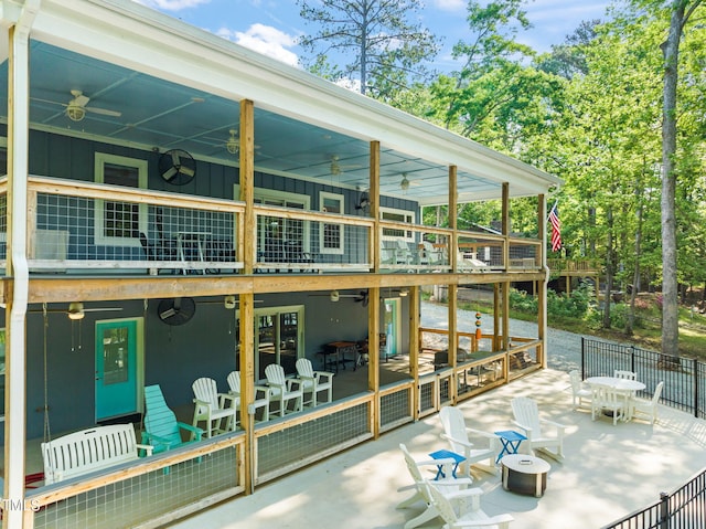 exterior space with a patio area, ceiling fan, board and batten siding, and fence