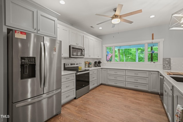 kitchen featuring decorative backsplash, ceiling fan, light countertops, stainless steel appliances, and recessed lighting