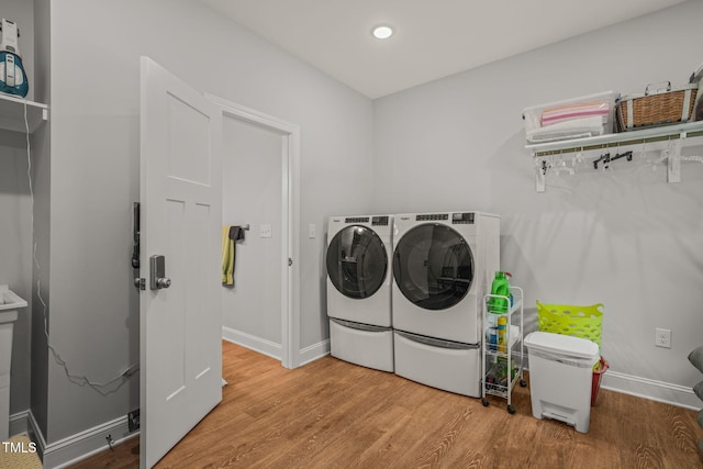 laundry room featuring laundry area, washing machine and dryer, wood finished floors, baseboards, and recessed lighting