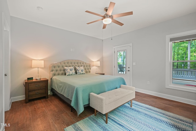 bedroom featuring baseboards, wood finished floors, and multiple windows