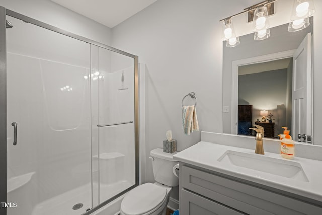 bathroom featuring vanity, a stall shower, and toilet