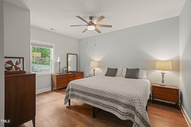 bedroom with visible vents, baseboards, and wood finished floors