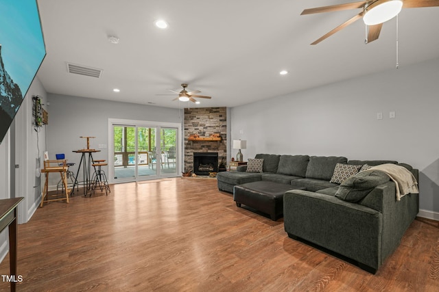 living room featuring a ceiling fan, visible vents, wood finished floors, and recessed lighting