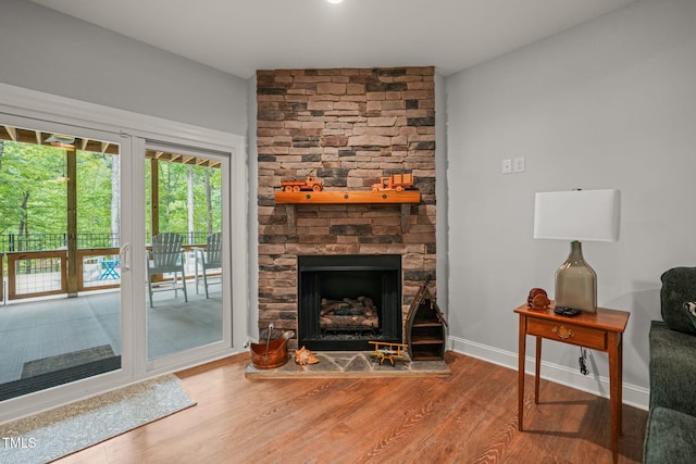living room with baseboards, a fireplace, and wood finished floors