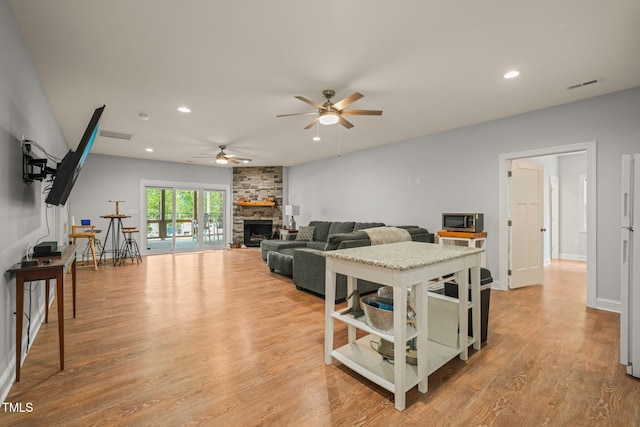 living room featuring light wood finished floors, a fireplace, a ceiling fan, recessed lighting, and visible vents